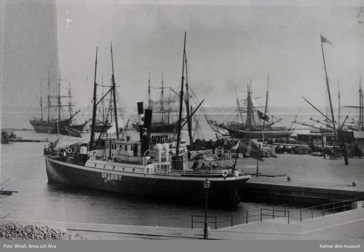 Vy över Tullhamnen med Gotlandsbolagets postångare Wisby i förgrunden och segelskutor i bakgrunden.