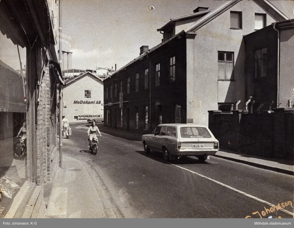 Kvarnbygatan i riktning mot Gamla Torget i Mölndal, år 1973. Till vänster ses huset Kvarnbygatan 37, i mitten nr 6 (MoDo Kemi AB) och till höger nr 4, Rasmussons skoaffär.