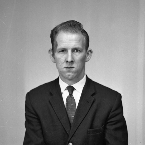 Foto av en okänd man i mörk kostym och slips.
Bröstbild. Ateljéfoto.