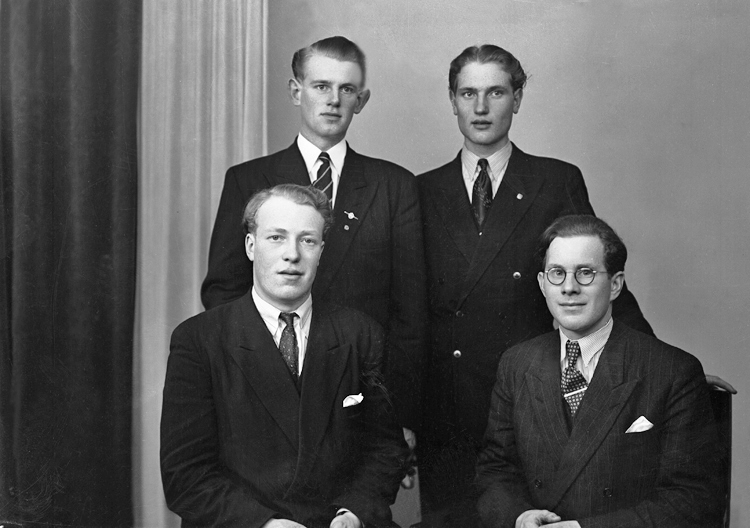 Foto av fyra okända unga män i kostym och slips.
Ateljéfoto.