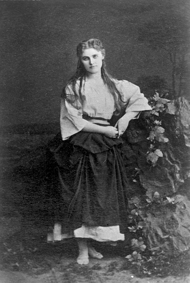Rollporträtt på Christina Nilsson där hon bär klänning, några blommor syns också. 
Mignon (AB).