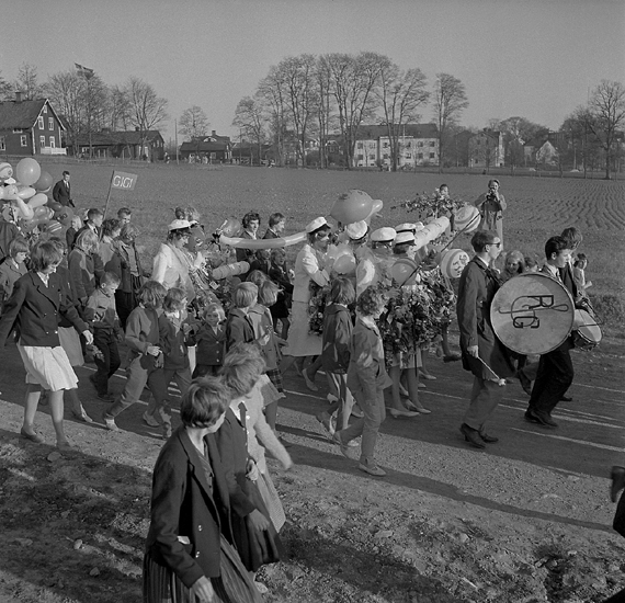 Studenterna, tredje d. 1960. 
Studenterna m.fl. tågar iväg nerför Fagrabäcksvägen.  I bakgrunden syns
några av husen vid Östrabo samt Prästänkehemmet.