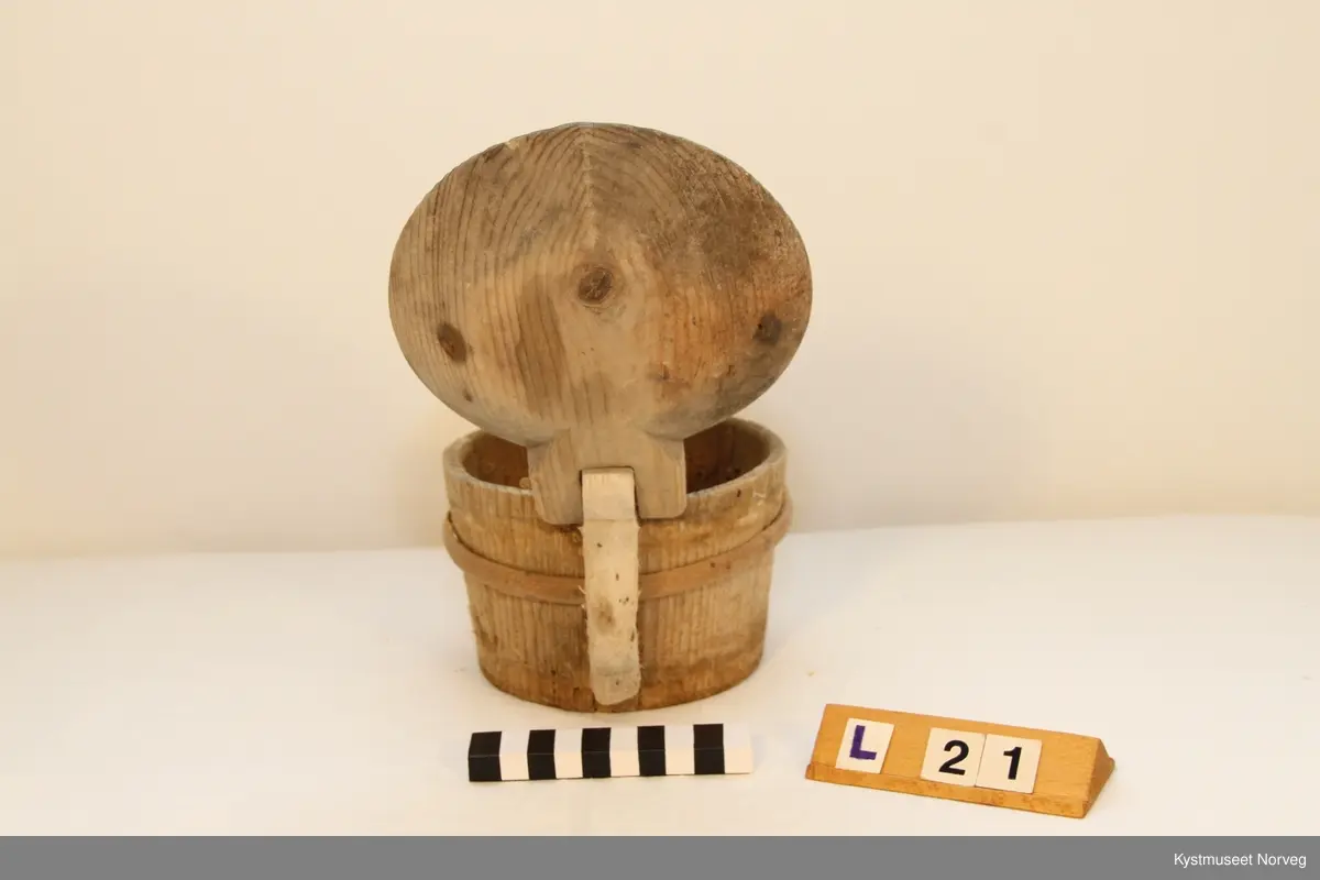 Smørkoppen er brukt til oppbevaring av smør. Treband; to nederst og et øverst. På lokke hank av jerntråd.