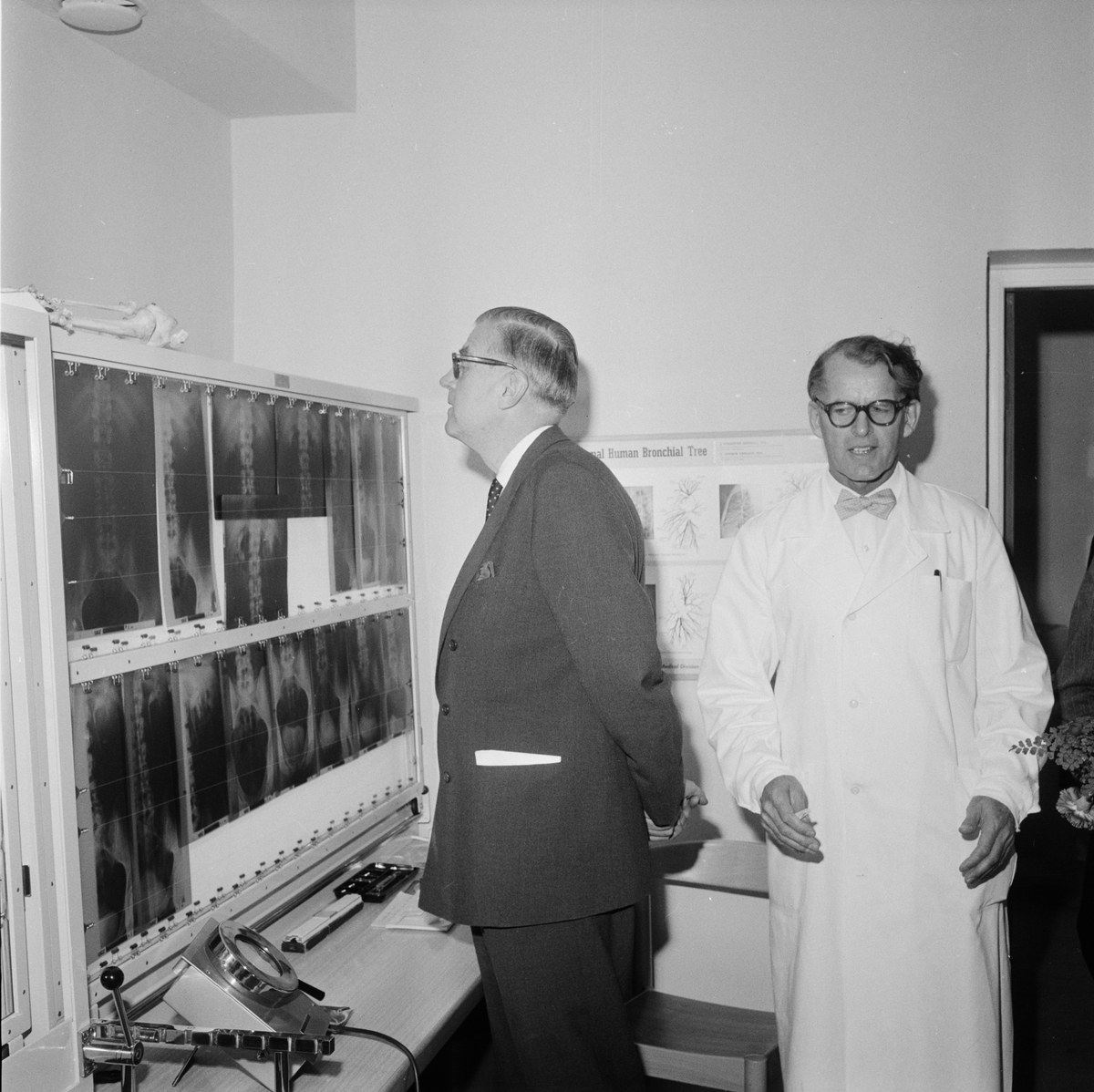 Generaldirektör Arthur Engel tittar på några plåtar i röntgenavdelningen vid invigningen av Enköpings sjukhus. Bredvid honom står överläkare Gösta Fallenius