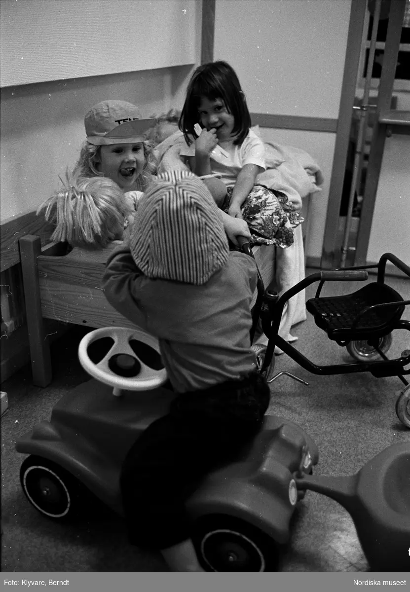 Barn med dockor och leksaksbil.