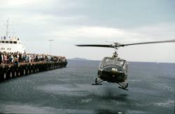 Helikopter ved dampskipskaia. Tilskuere står og ser på.