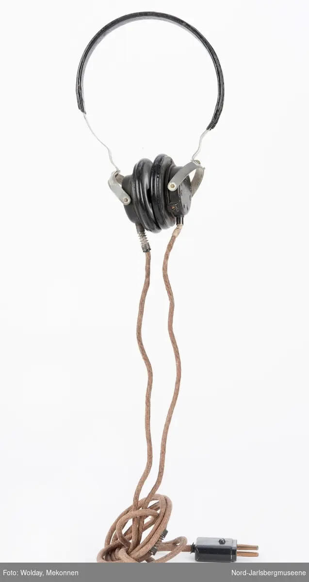 En bøyle med to øreklokker som hver er koblet til en delt elektrisk ledning, som har tekstilisolasjon.