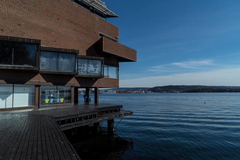 Brygga ved Norsk maritimt museum, blått vann til høyre.