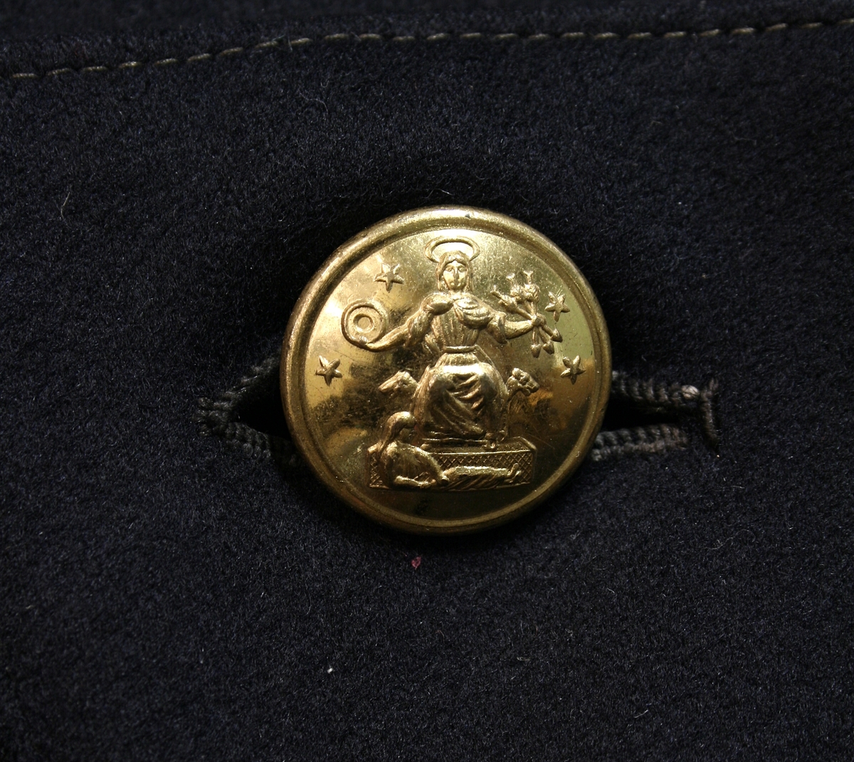 Modell 1877 (?) for konstabel, 
dobbelspent med 7 knapper i hver rad, 3 knapper bak på hver av frakkeskjørtene. På den opprettstående kragen konstabelnummeret 9 i messing og en stjerne. 

Buksen har rød passpoil. Det er uvisst om denne hører til.