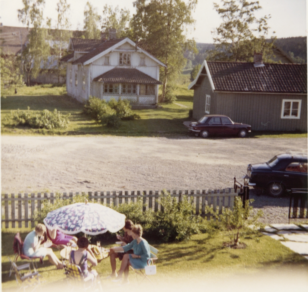 Selskap i hagen. I bakgrunnen ser vi Braate gård. Oppigarn ca. 1968.