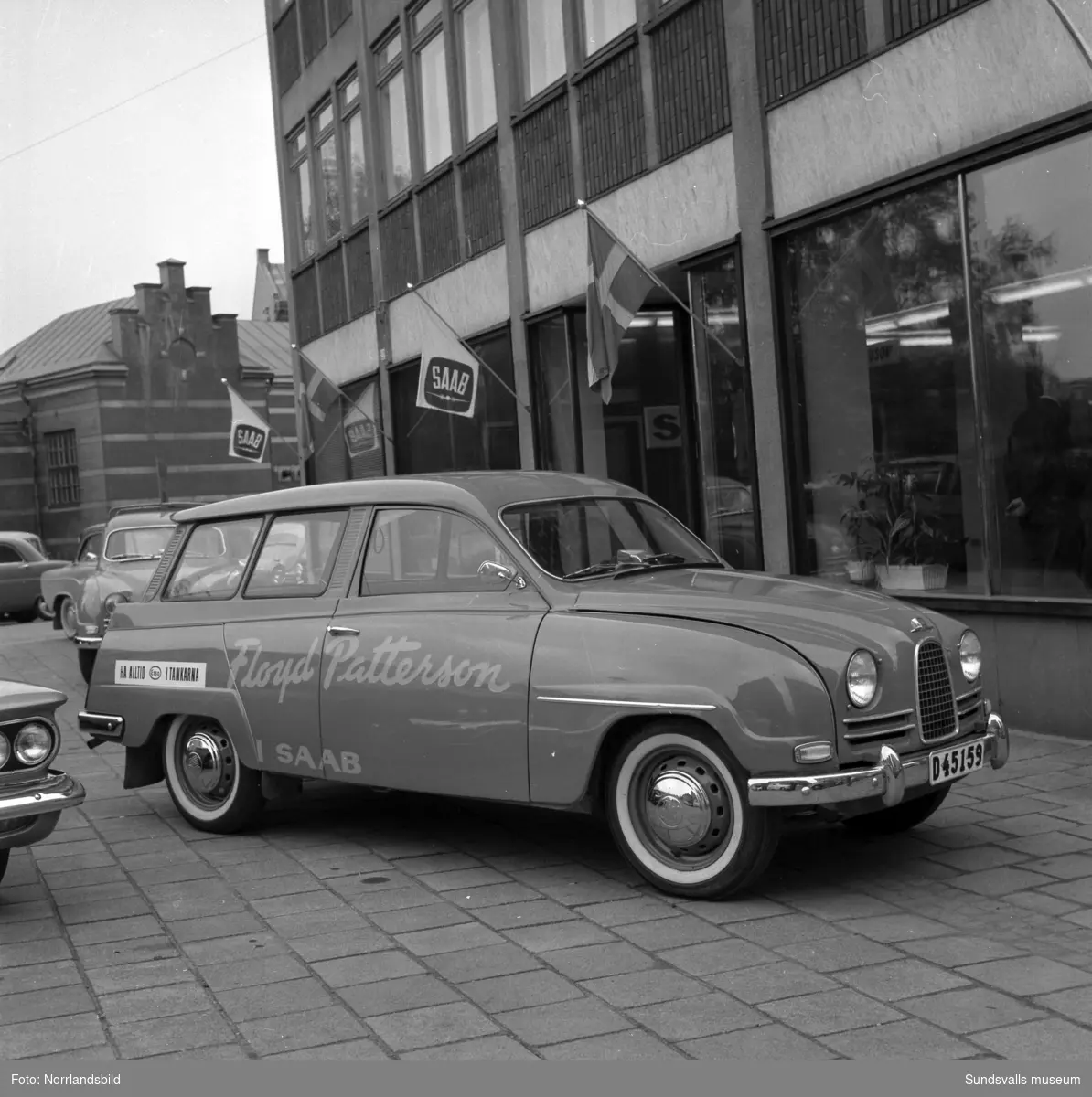 Saab ANA visar upp bilar med Floyd Pattersson-reklam utanför bilhallen på Köpmangatan 1.