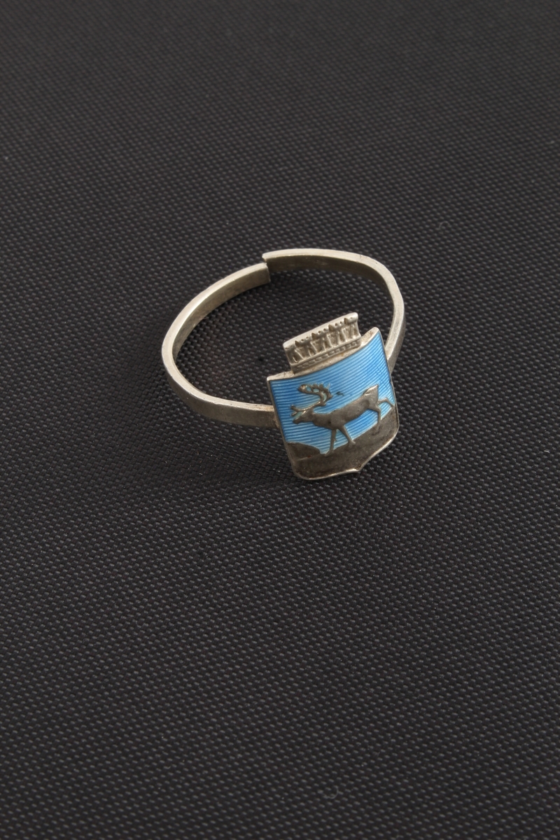 En ring i sølv/emalje 925 sølv, med et dekorelement med motiv av en hjort mot blå bakgrunn.