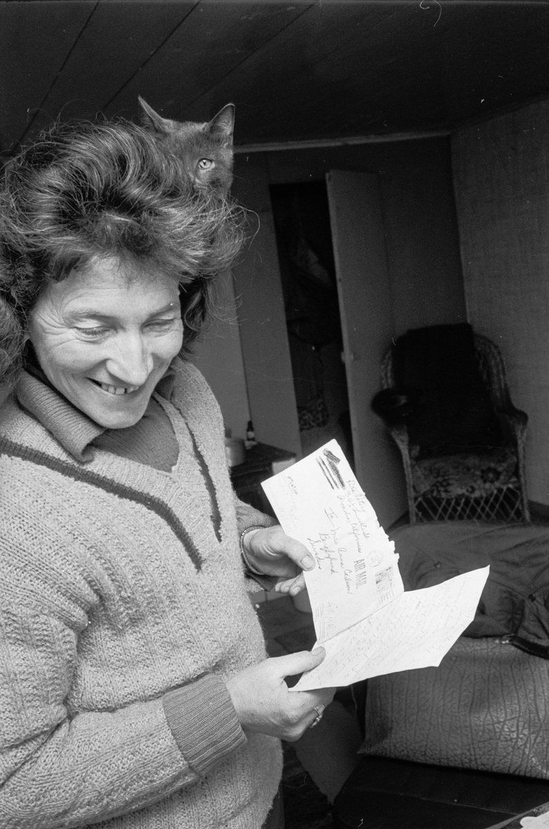 Clary Huldt med katt på axeln läser brev, Riala, april 1967