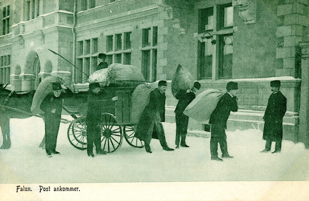 Vykort med fotografiskt motiv. Postiljoner lastar av en hästdragen kärra utanför postkontoret i Falun, omkring 1900. Vykortet är avsänt till Storvik med Postiljonskupé 283B den 2 juni 1906.