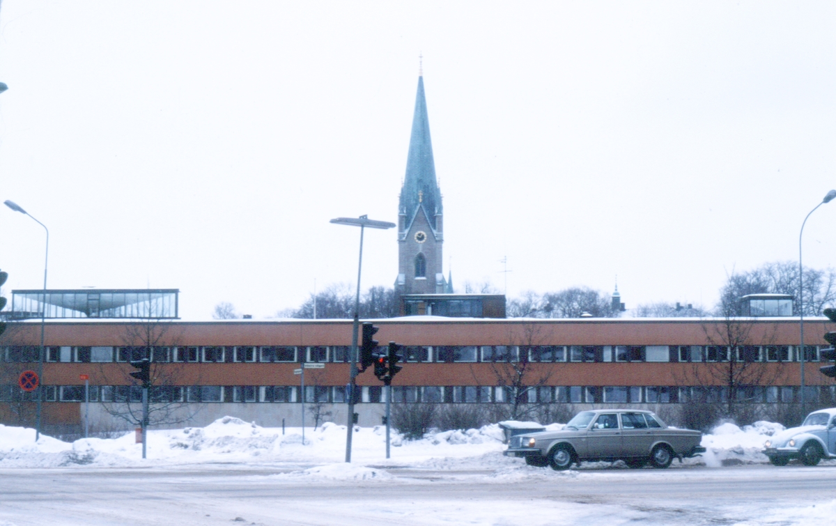 I förgrunden ses parkeringsplatsen framför Länsstyrelsen tagen från Östgötagatan, i bakgrunden ses domkyrkan.