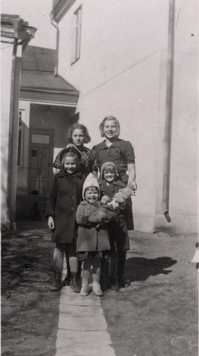 Bilden visar Kerstin, Lilly, Gudrun, Inger och Ulla Andersson framför huset på Drottninggatan 15, Linköping. Inger Lilja hette Andersson som flicka.