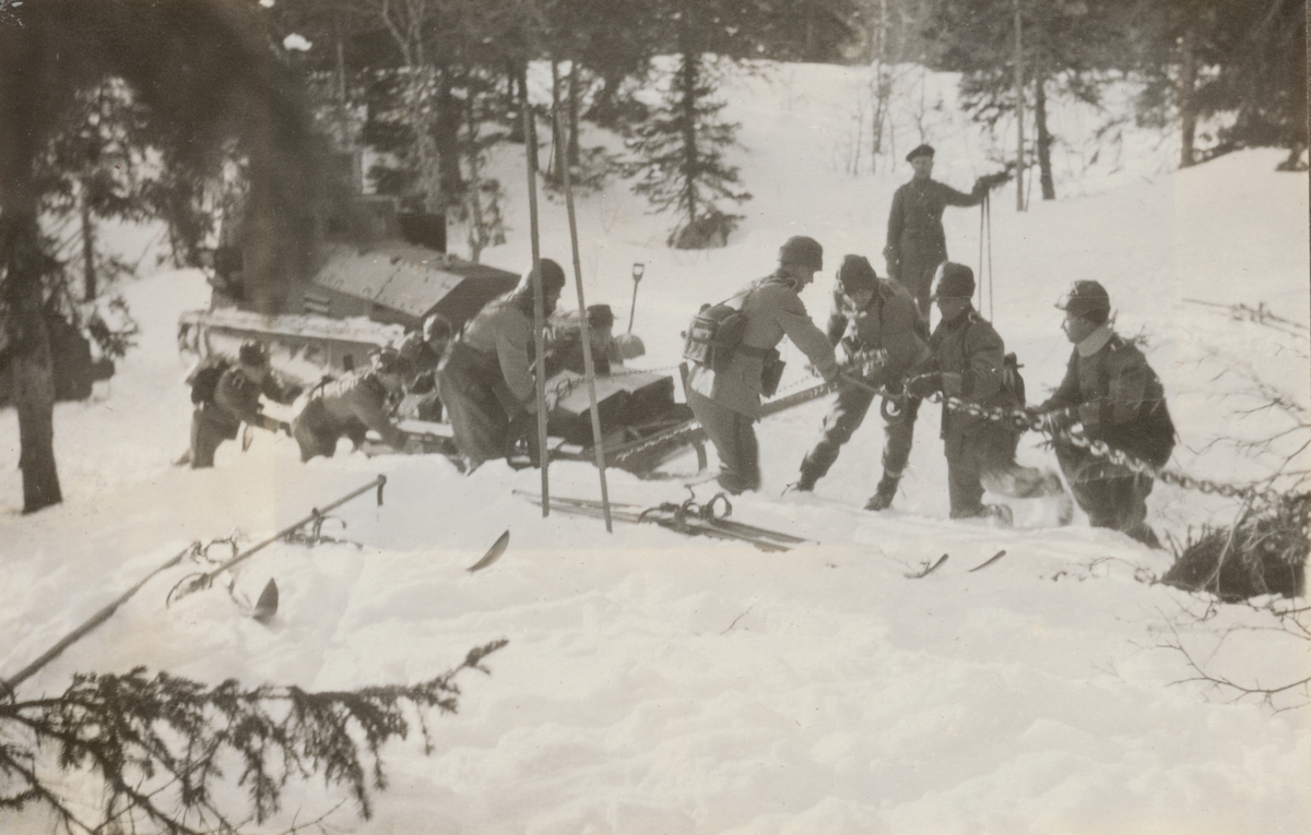 Stridsvagn m/1921 (eller m/1921-1929) fast i snö. Elever från stridsvagnskursen vid Göta livgardes stridsvagnsbataljon fäster dragkedjor för att få loss vagnen.