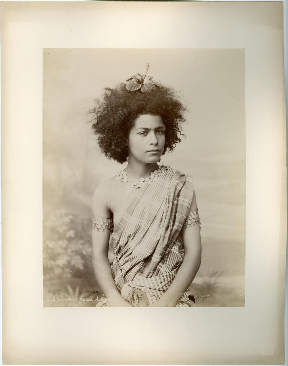 Porträtt av en kvinna med en blomma i håret.