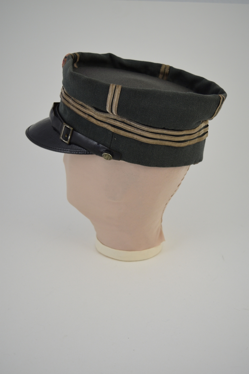 Form: a) Uniformslue: oval pull, rette kanter, påsydde sølvbånd.
