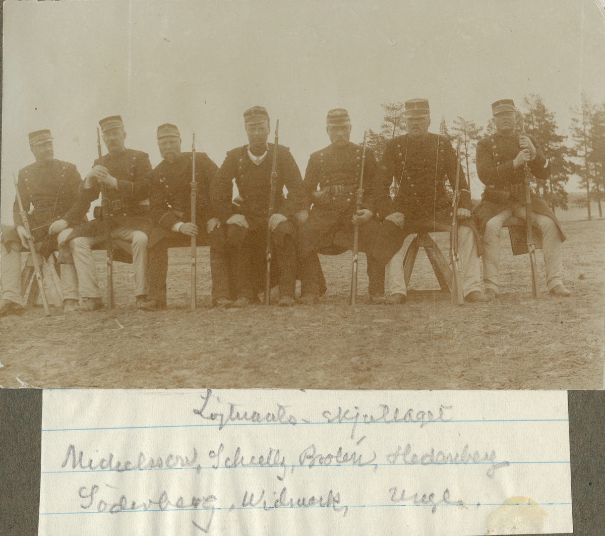 Gruppbild med skjutlaget sittande på en bänk vid Hälsinge regementes övningsplats Mohed.
