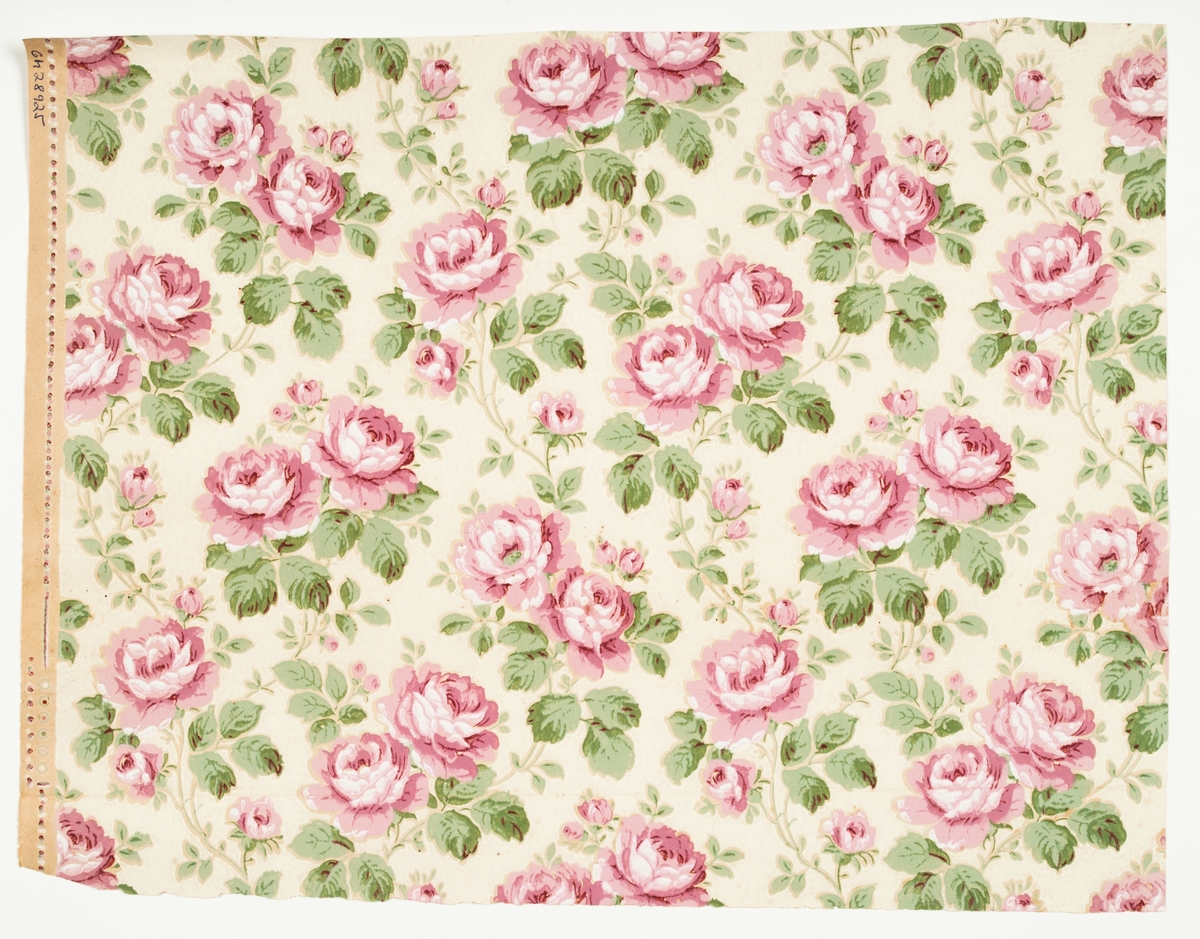 Tapet med slingrande rosenrankor i nyanser av rosa och grönt mot gulvit fond, tryckt på obestruket papper. Papprets färg är synlig genom utsparningar i mönstret.’