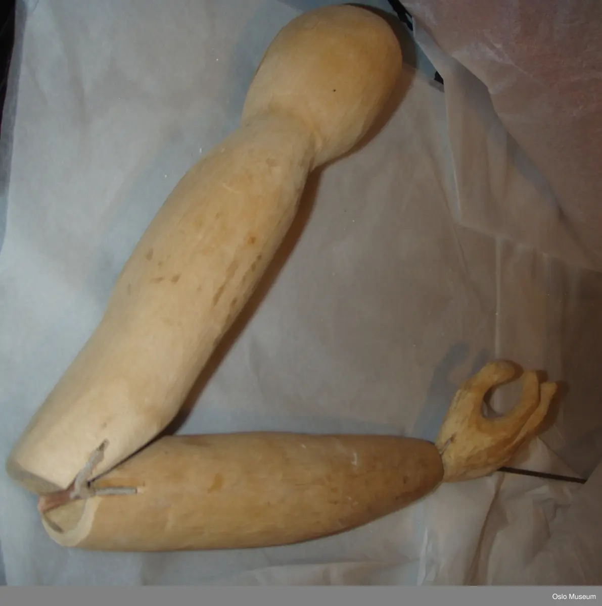 Stangdukke, mann fra "Antigone" av Sofokles.
Ansiktet er gips og gasbind. Håret er stål som er bøyet og formet med strimler av gasbind og gips rundt om på hodet. Inne i masken er det sort plast og teip. Hodet står på en trestang som er festet med plasttråd. Trestangen går ned gjennom brystet som dukkeføreren kan bruke til å bevege hodet med.Trestangen  er festet med stål og hemper.
Brystkassen er hønsenetting. Farget gasbind i blå og rosa er limt på. Armene er i tre og bevegelig i skulder-, albue- og håndledd. Skinnlapper mellom treverket danner leddene.
Dukken har på seg forskjellige tøystoffer som henger løst ned langs kroppen i blå, fersken og brun. Armene er festet til hønsenettingen med et beige silkeaktig stoff som henger ned langs armene.