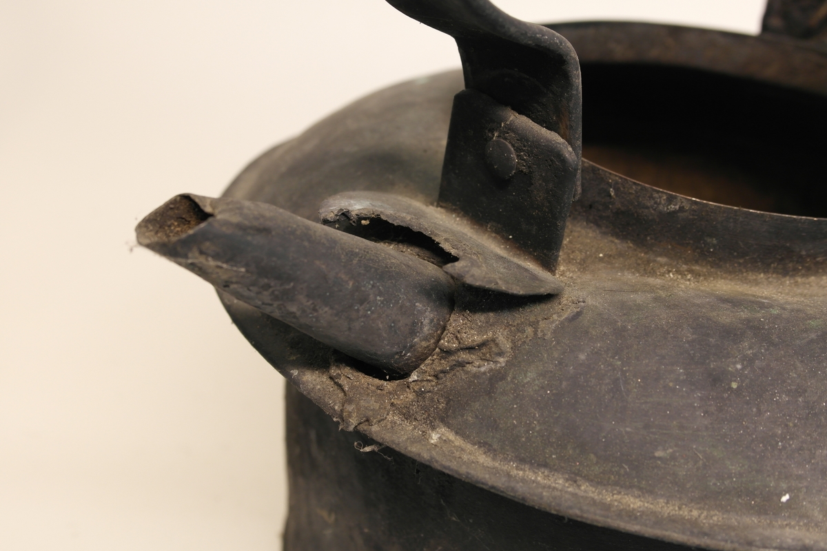 Kaffekjele (A) med lokk (B), laget av hamret og loddet kobber, med innvendig fortinning. Kjelen har en rett, sylindrisk form som er bredest øverst. Den er beregnet på komfyr med ringer.