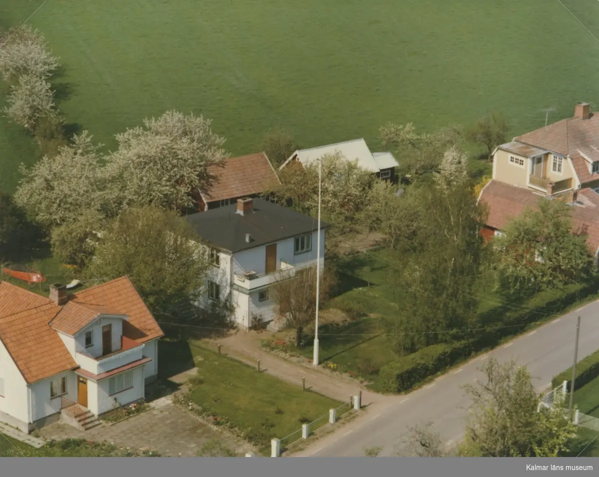 Flygfoto över Pataholm. Bostadshus med sidobyggnad och trädgård samt äng.