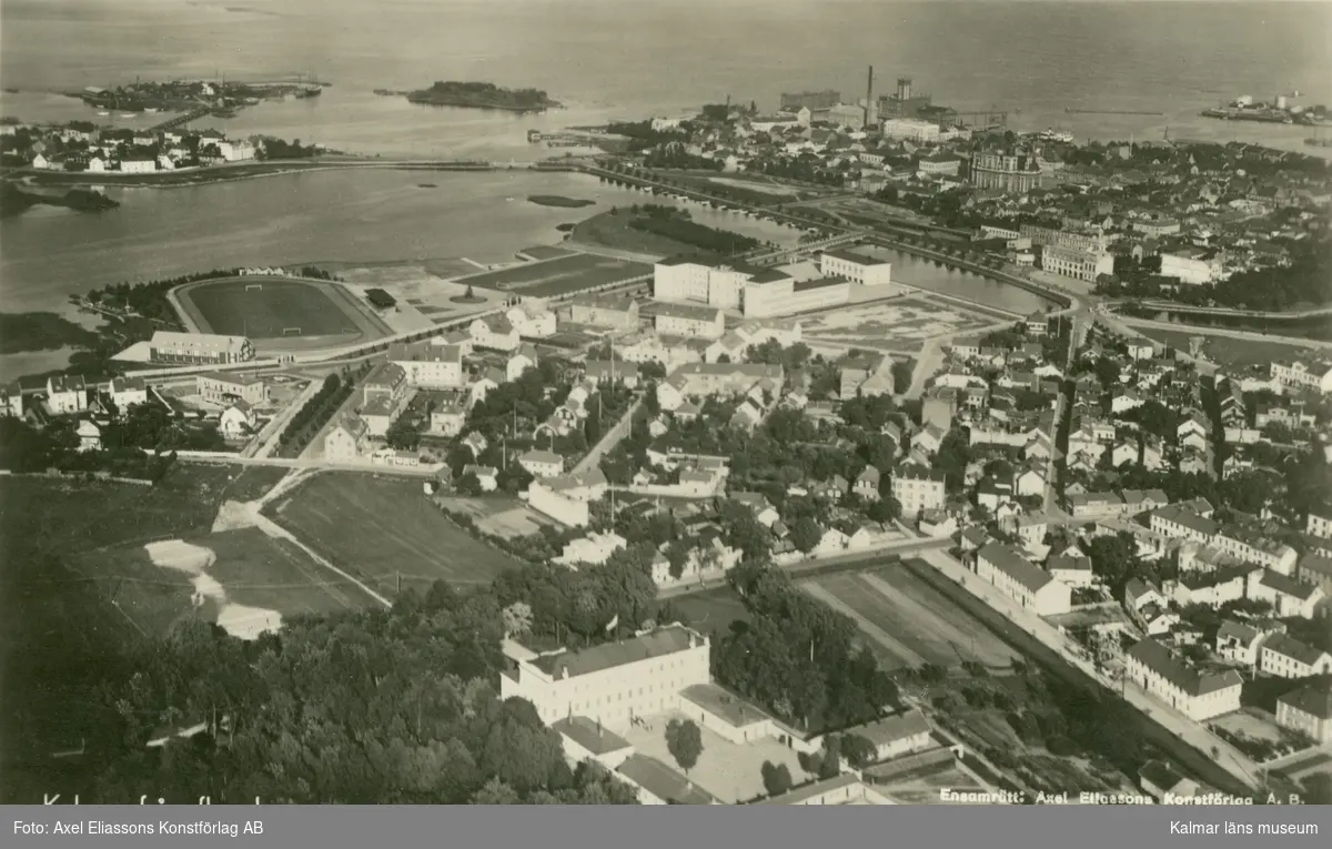 Flygfoto över Kalmar. Centrum med idrottsanläggning, skola, domkyrka och stadsbebyggelse.