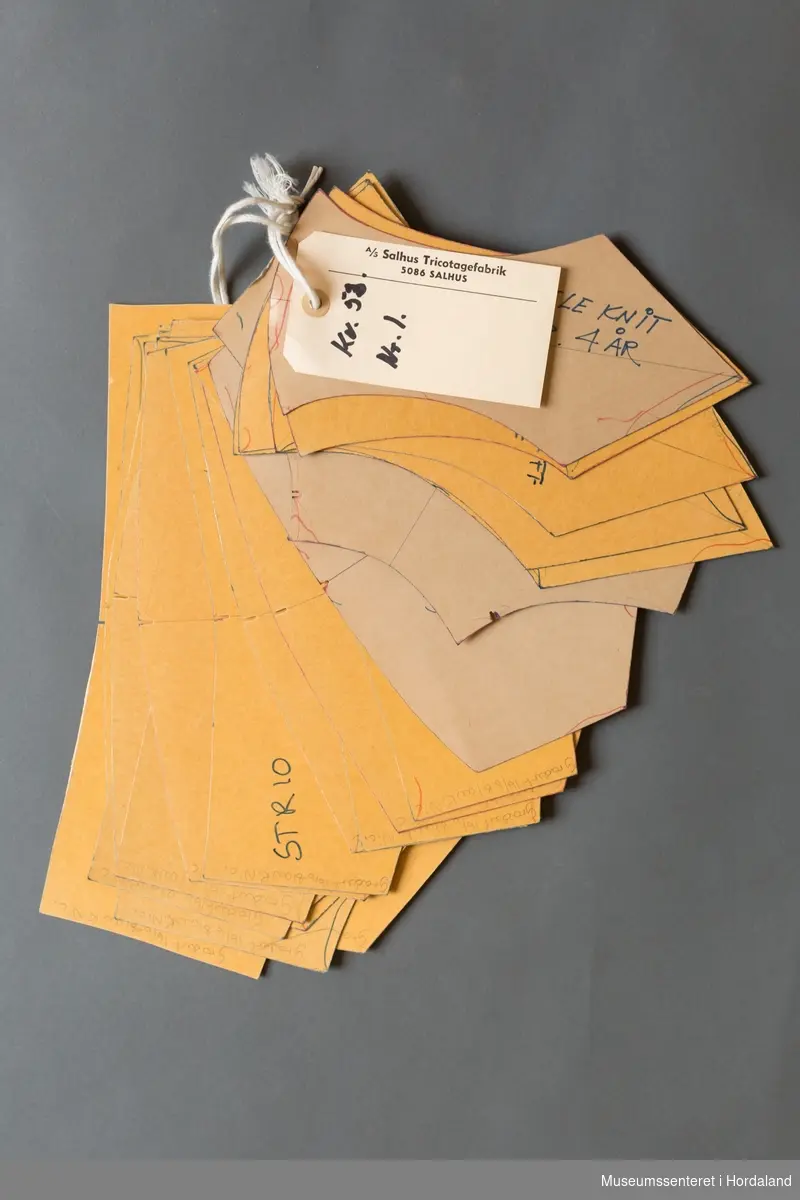 Mønsterskantar i papp, brukt til å skjere ut ulike delar av plagg i klesproduksjon. Desse er til ein truse i kvalitet 58, nr. 1. Str. 4-16 år.