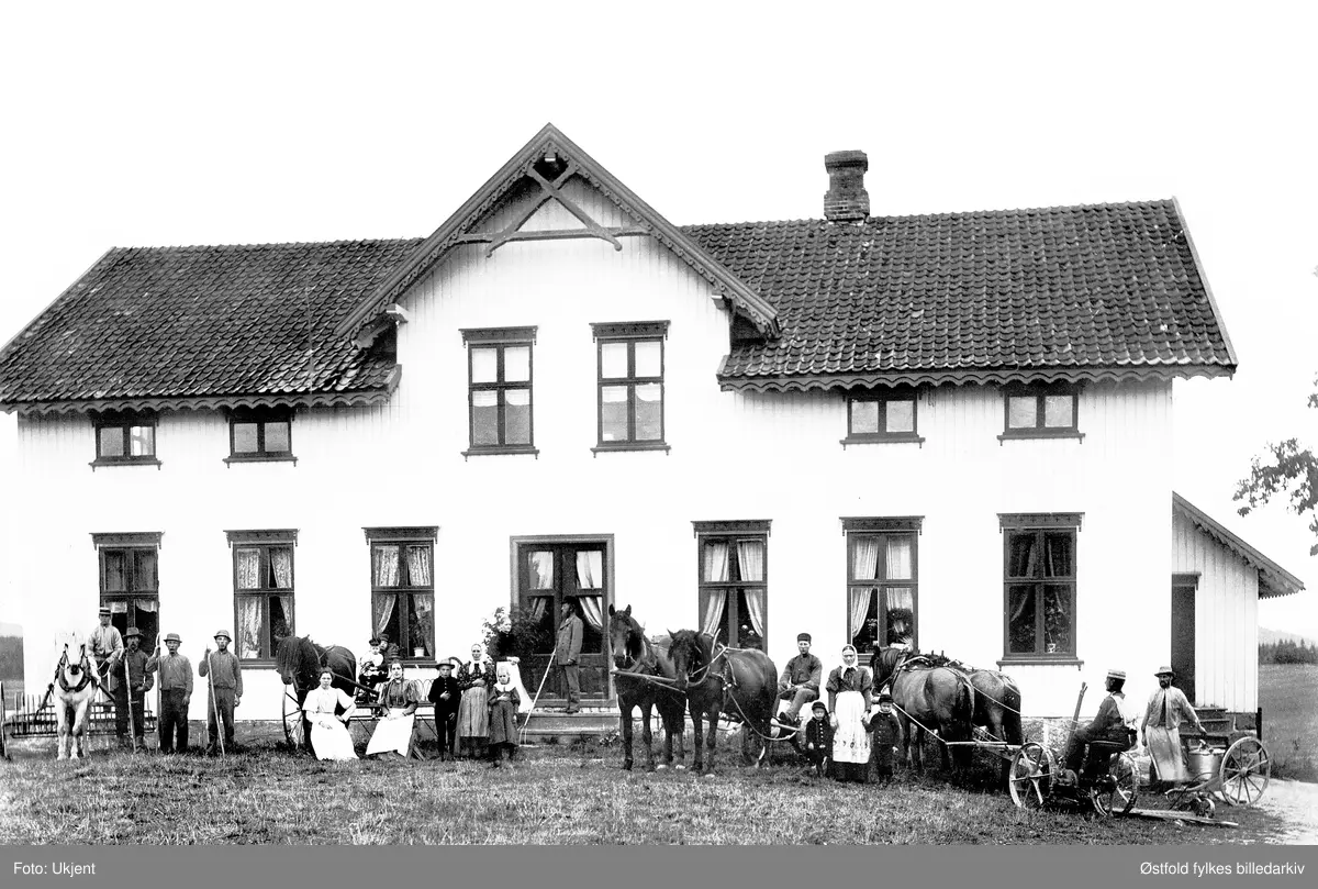 Herseter i Trøgstad, med familien Henningsmoen med flere.
Fra venstre: Håkon Henningsmoen (på kjørerive), på hans fang Ingeborg (født på Herseter i 1895). På trappa Mariane Henningsmoen (f. Krog) og Ole Jensen Henningsmoen.