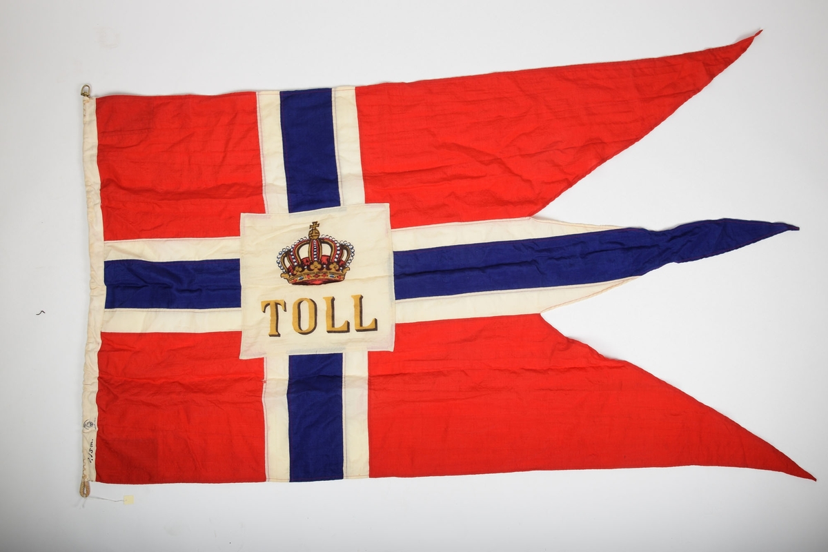 Norgesflagg med "TOLD" skrevet på midten. Over teksten er det avbildet en krone. Bånd i venstre kortside, for oppheng. 3 spisser i den høyre siden.