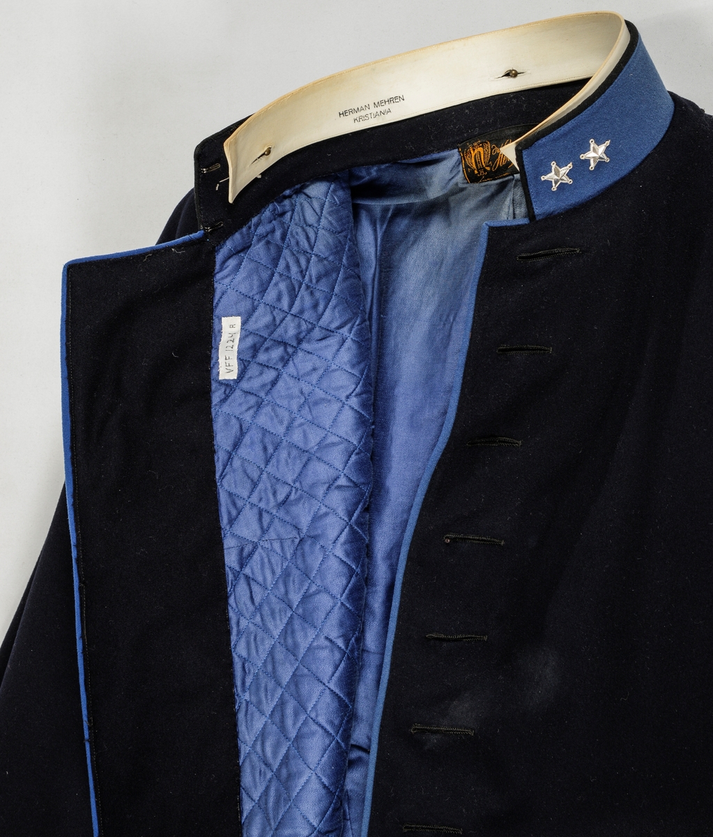 Uniform, løyntnantsuniform, i svart klede med kantar i blått klede. Registreringa inneheld A. Trøye, B Bukse, C Lue, D og E Pålettar. Sjå nærare fyldig registrering på arkivkort frå 1969.