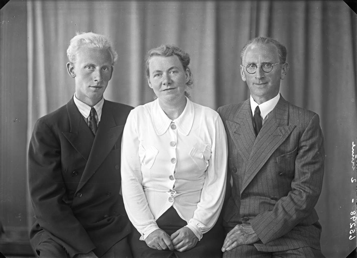 Portrett. Familiegruppe på tre. To menn og en kvinne. Bestillt av Erling Ellingsen. Storesund. Skåre.