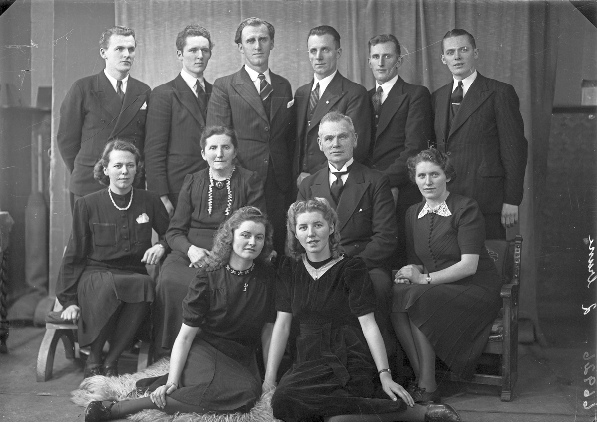 Gruppebilde. Familie. Gruppe på 12, en eldre mann, ei eldre kvinne, seks unge menn og fire unge kvinner.  Bestilt av Claus Dale. Skudenes.