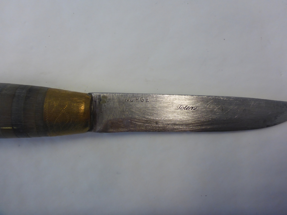 En Dahlkniv. Stemplet Toten. og norge. Laget under krigen, ettersom at det ikke var å få tak i nysølv, men kun messing. resten av kniven er laget av kuhorn.