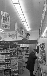 Interiør i kolonialbutikk.
Kunder på jakt etter gode kjøp.