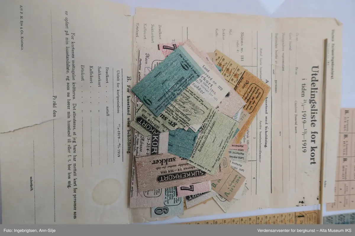 Konvolutt med mange rasjoneringskort. Det er kort for blant annet brød, erter, kaffe og sukker.