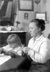 Marie Lagertha Lauritzen strikker med Dagar Lauritzen ved si