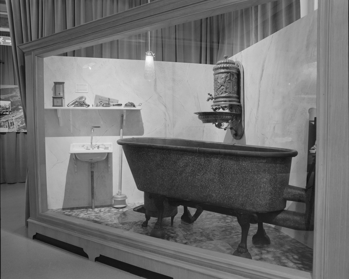 Dokumentation av utställningen "Teknikens under för 100 år sedan", Elkraftsmuseet. Monter med badkar, tvättställ och varmvattenberedare m.m.
