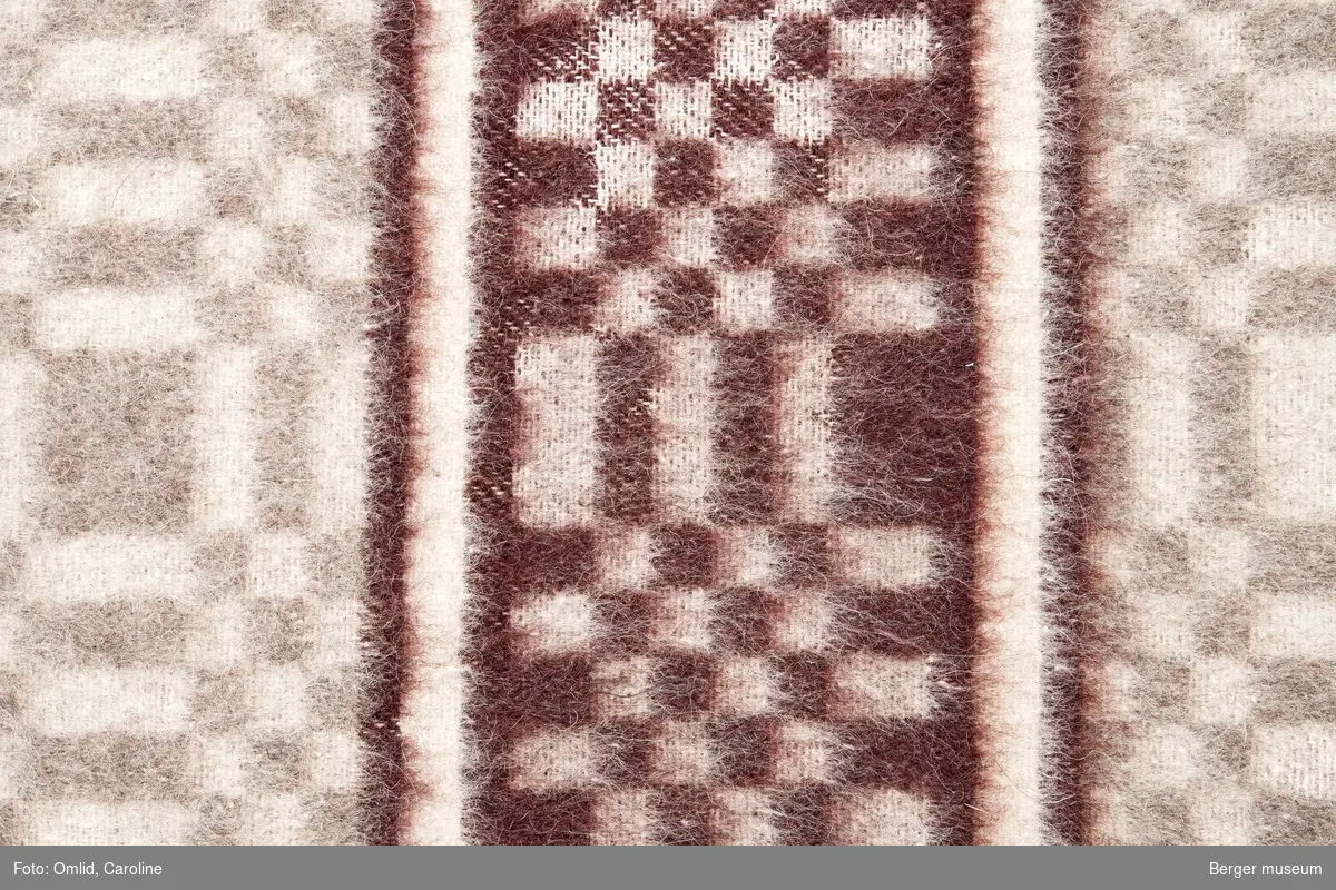 En prøve. Teppe med gjentagende mønster som blir brutt av samme mønsterbord i en annen farge.
Mønsteret er en ørliten variasjon over BMF.03587-C-1.