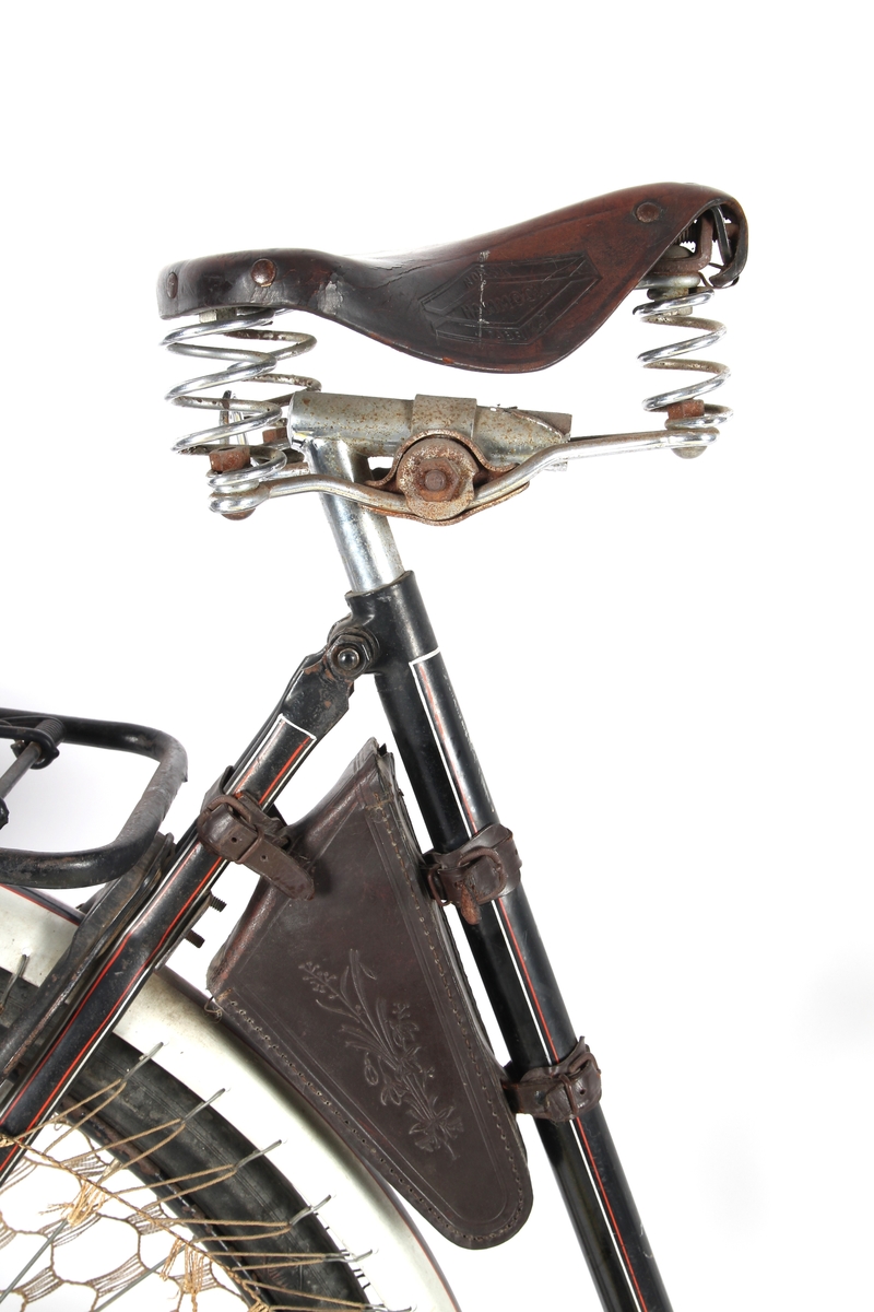 Svartlakkert damesykkel med taske til verktøy under setet og kjolenett på bakhjul. Torpedo frinav med innebygd trommelbrems.