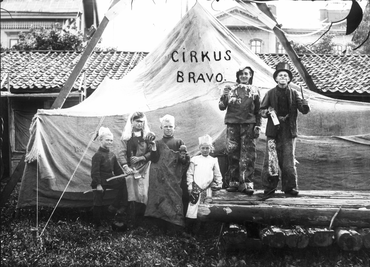 Sex barn leker cirkus. Förmodligen är lekplatsen belägen i kvarteret Plantagen, nuvarande museitomten. I bakgrunden syns Islandsskolan.