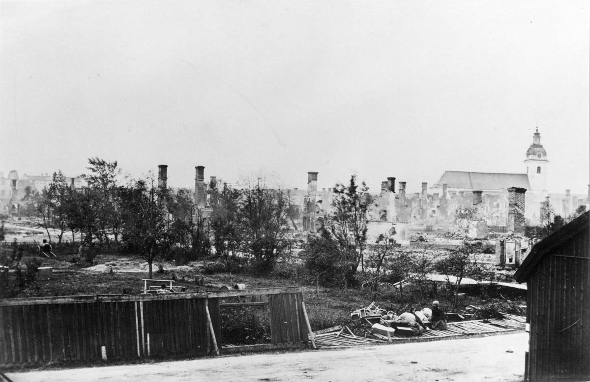 Efter Gävle brand 1869. Utsikt från hörnet av Norra Kungsgatan och Staketgatan. Planket i förgrunden innesluter läroverkstomten.
