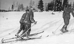 Menn, uniform, ski og skistaver, naturforhold. 
Troppsjef m