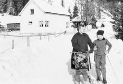 Bolighus, personer, klær, ski og skistaver, spark.