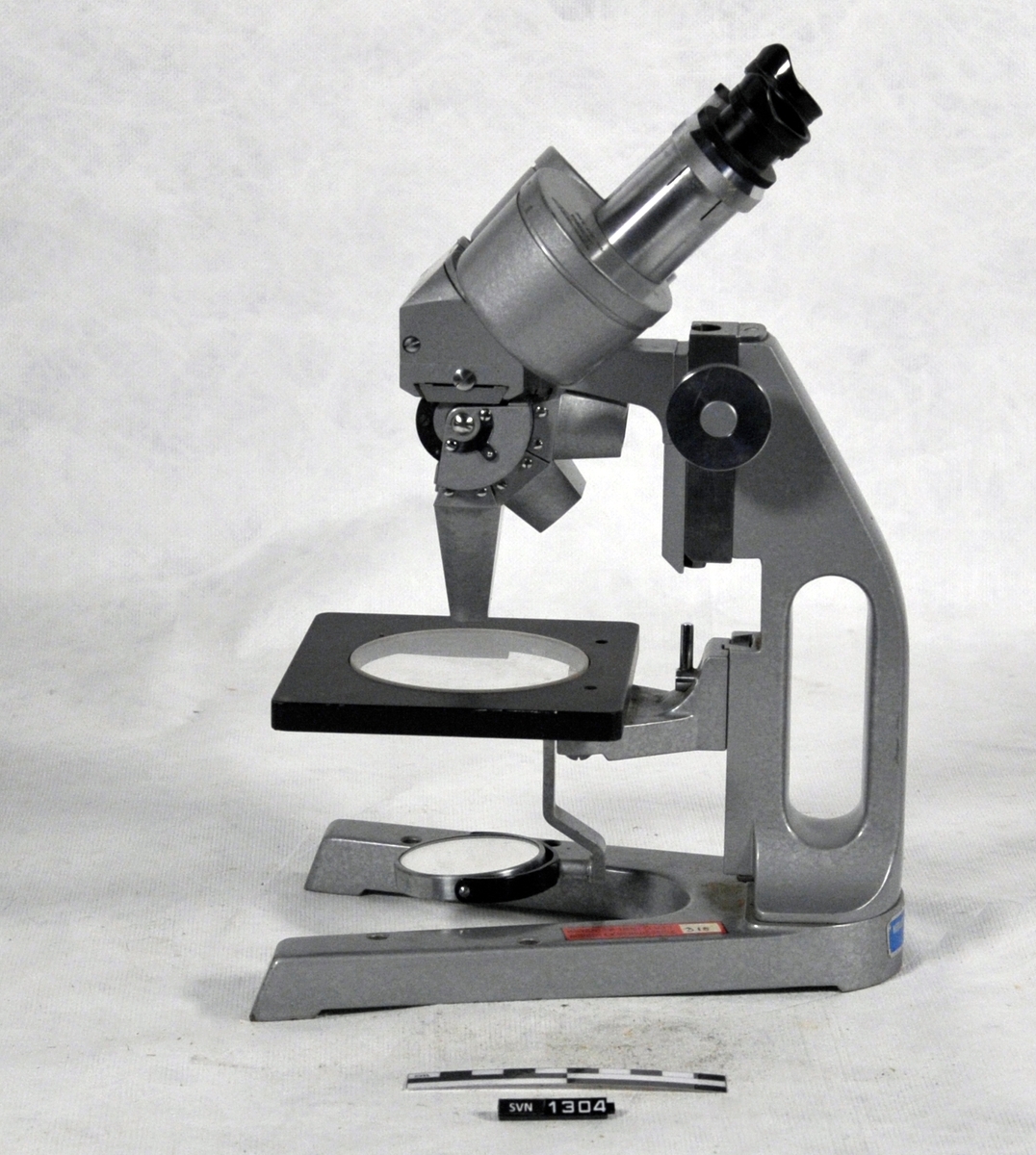 Gjenstanden er et mikroskop i kasse, med utstyr.
Oppbevaringskassen er laget av tre, på en side er det en dør. På toppen er det et håndtak. I håndtaket er festet en snor, i den andre enden av snoren er det en sort pose som inneholder nøkkel til kassen.

A er oppbevaringskasse
B er mikroskop