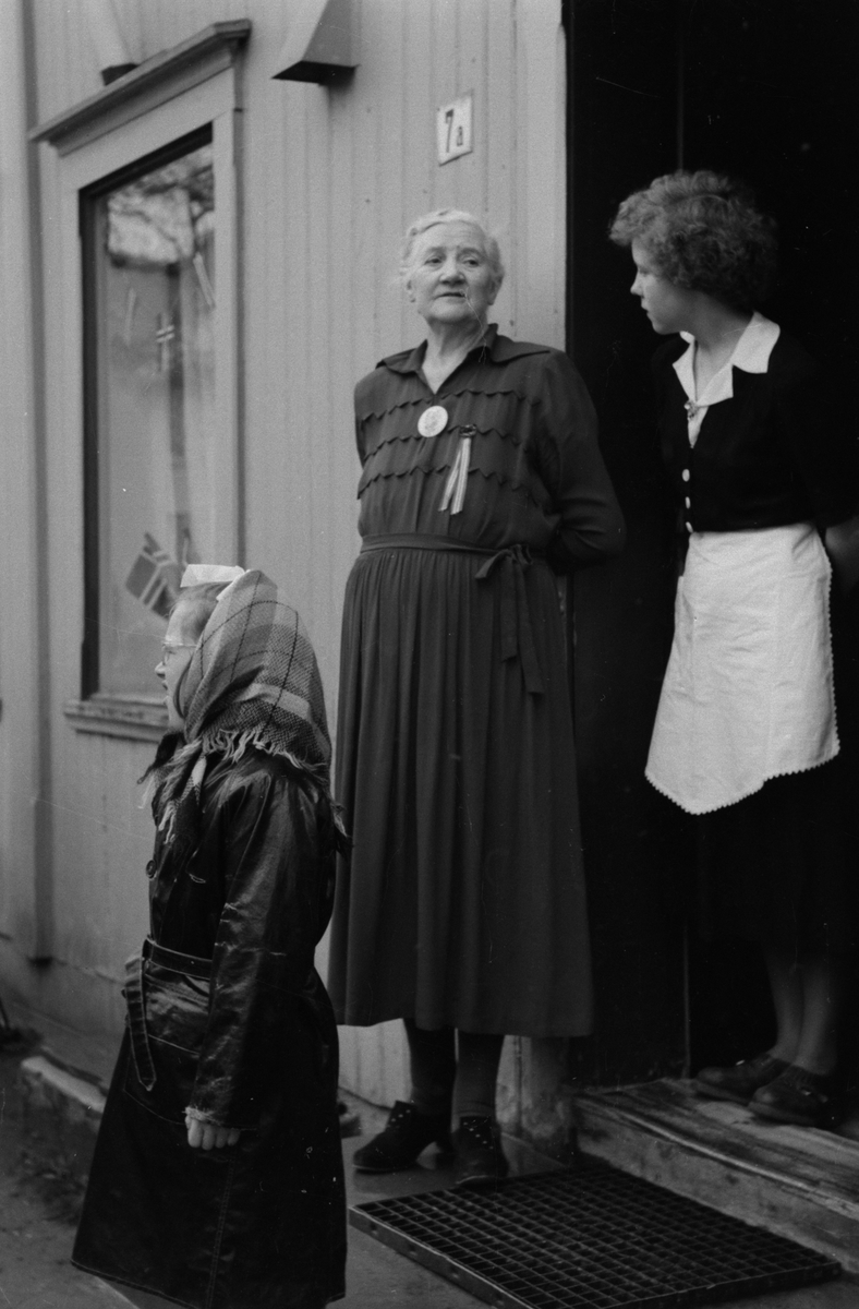 Olga Andersen og ei servitrise på trappa til Tipperary Cafe og Spiseforetning 17.mai 1951,mens de venter på Mosjøen Hornmusikk.