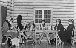 Kvinner, strikketøy, bord og stoler.