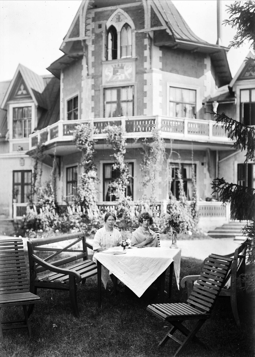 Husan Alice Vestrin och kokerskan Frida Gustafsson sittande vid bordet på stora planen, Göksbo, Altuna socken, Uppland 1926